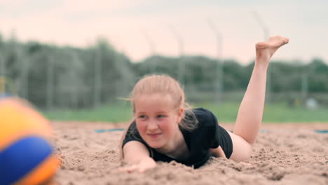 Slow-motion:-a-Young-woman-jumping-in-the-fall-hits-the-ball-on-the-sand.-Volleyball-player-makes-a-team-and-plays-the-ball-off-in-the-fall.